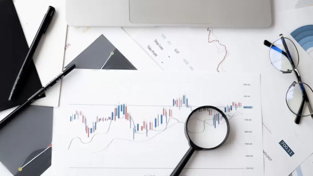 Professional team working on análisis de mercado especializado with documents and charts on modern office desk